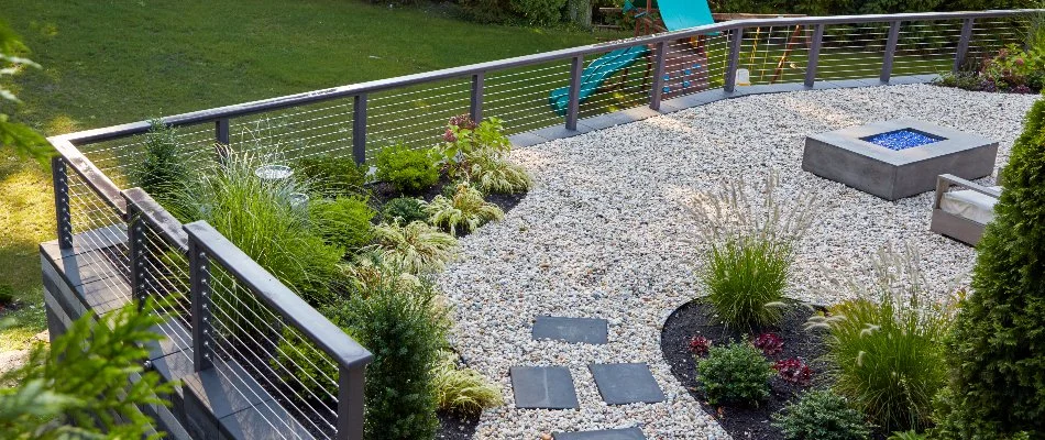 Fence around a gravel patio in White Plains, NY, and landscaping.