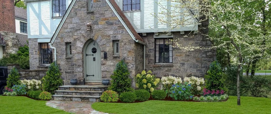 Plants and green grass in front of a house in White Plains, NY.