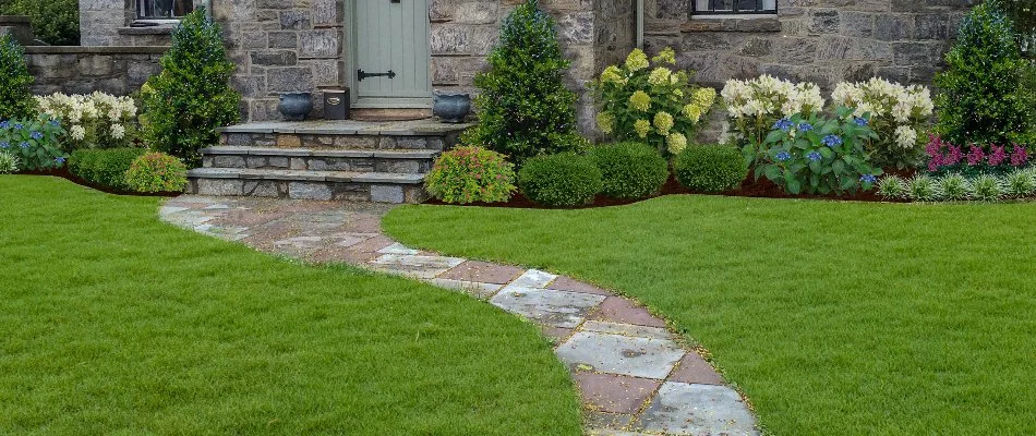 Green lawn and landscape bed with colorful flowers on a property in %%targetarea1%%, NY.