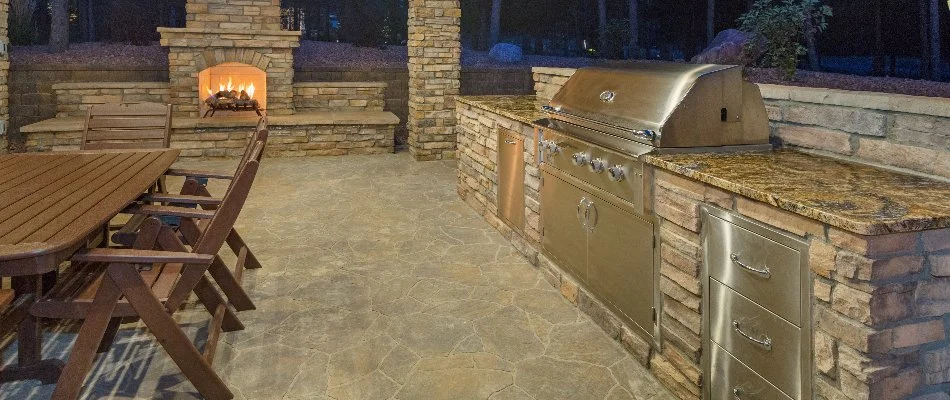 Outdoor kitchen, fireplace, and a table in White Plains, NY.