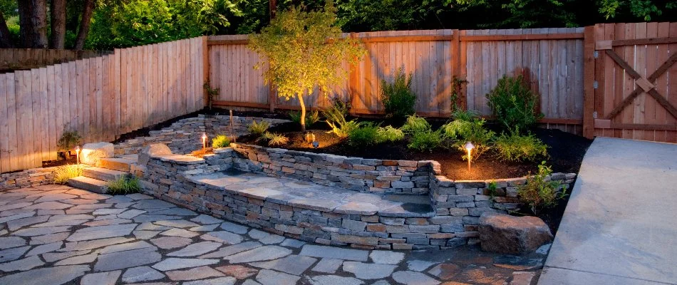 Lighting illuminating plants and retaining wall on a property in White Plains, NY.