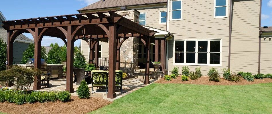 Wooden pergola next to a green lawn on a property in White Plains, NY.